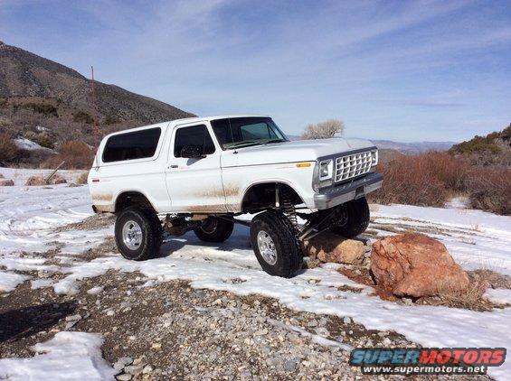White 1979 Ford Bronco with lifted suspension on rocks and snow