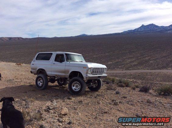 White 1979 Ford Bronco with lifted suspension parked on a dirt road