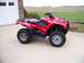 1984 Honda ATC 250 R - A red Honda all-terrain vehicle is parked on a concrete driveway in front of a garage.