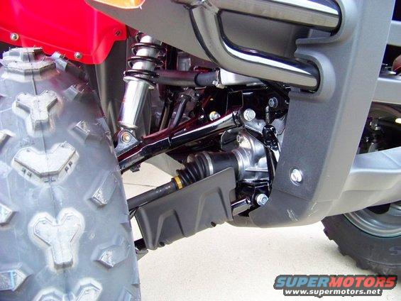 Close-up of an ATV's front tire, suspension, and drive shaft boot