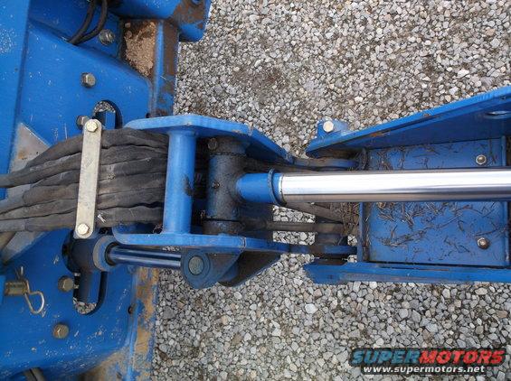 Blue hydraulic cylinder attached to a metal frame with rubber hoses
