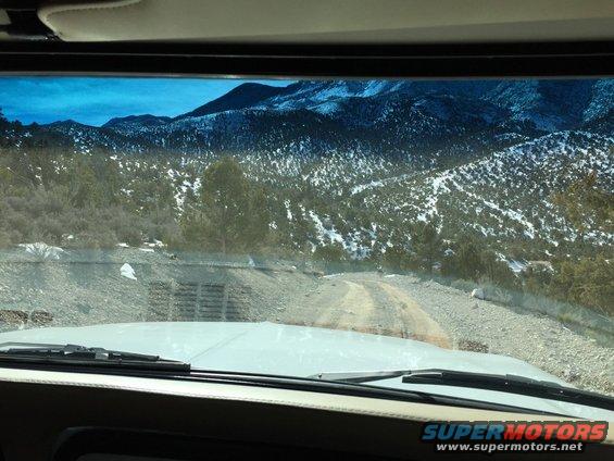 View from inside a vehicle looking out at a snowy mountain road