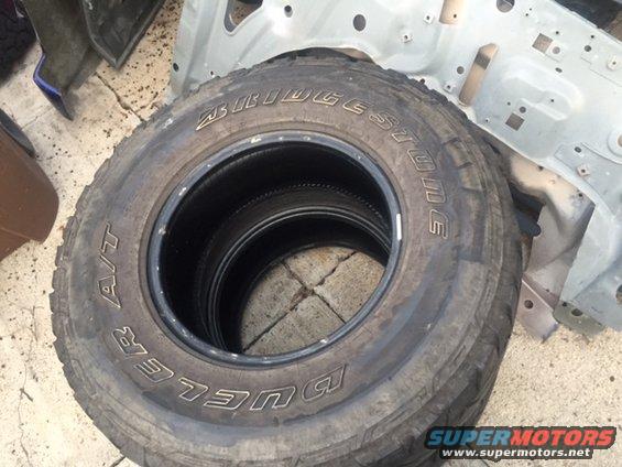 Bridgestone Dueler A/T tires stacked, showing tread and sidewall