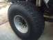 1986 Ford Bronco - Close-up of a BFG All-Terrain KO tire and wheel, part of a vehicle's suspension system is visible.