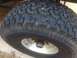 1986 Ford Bronco - A close-up shot focuses on the tread of a large off-road tire mounted on a silver alloy wheel.