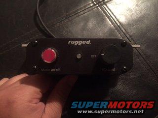 Radio intercom unit with red music on/off button and black volume knob