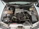 1999 Ford Fairlane - The engine compartment of a car is shown with the hood raised, revealing the engine and various components.