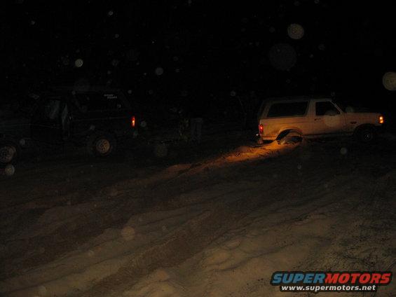 1994 Ford Bronco side view at night, one wheel stuck in sand