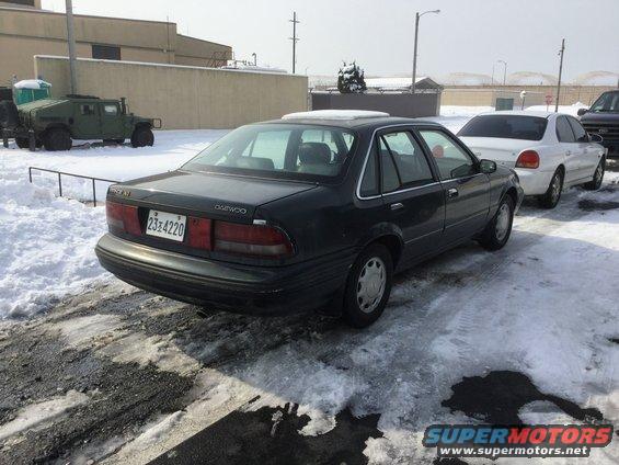 Dark sedan rear view with Daewoo badging and license plate 23-4220