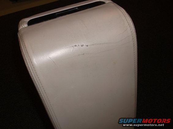 light-colored car armrest with some scratches on top