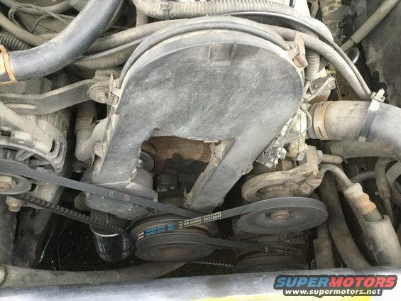 Engine bay showing belts, pulleys, and air intake housing