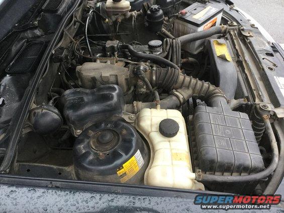 Engine bay with battery, coolant reservoir, and air intake system