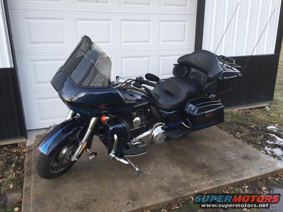 Dark blue 2013 Harley-Davidson FLHX parked in front of a garage door