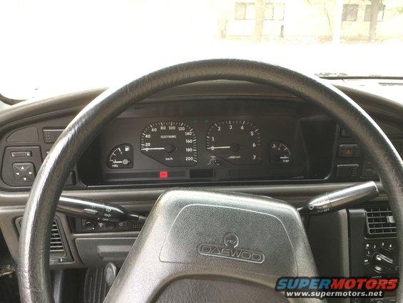Daewoo steering wheel and dashboard with fuel and temperature gauges, speedometer, and tachometer