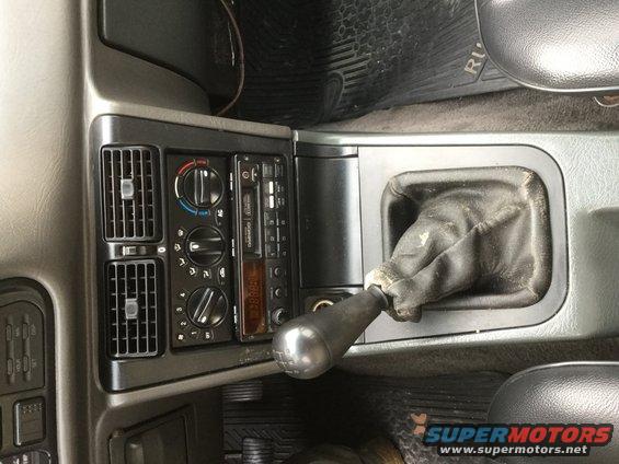 Interior view of a manual gear shifter and radio console