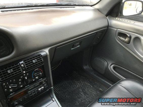 Car interior showing dashboard, air vents, radio, and door panel