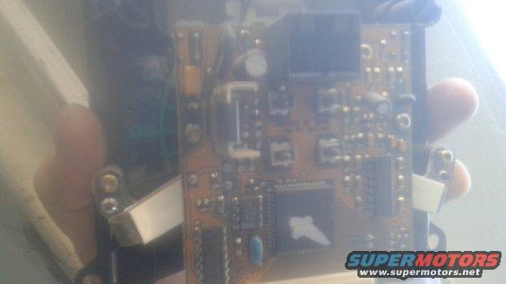 Electronic circuit board with various components and a large black chip