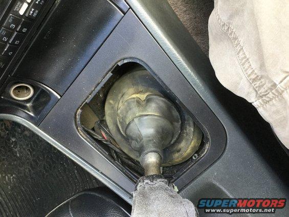Interior view of a car's gear shifter boot and linkage mechanism