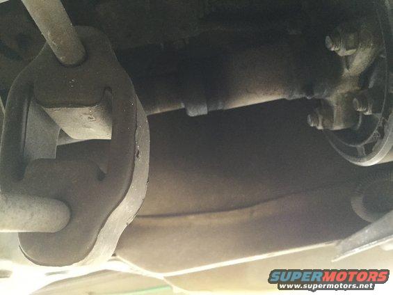 Exhaust hanger and pipe assembly on underside of vehicle