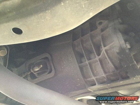 Underside view of vehicle transmission and exhaust pipe with Supermotors logo