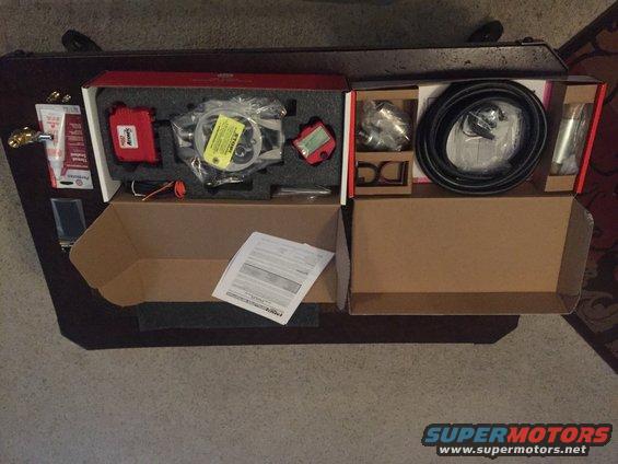 Unboxed automotive parts including a throttle body, wiring, and hoses