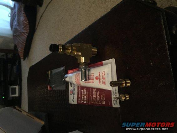 brass T-fitting with hose barbs and a tube of Permatex thread sealant