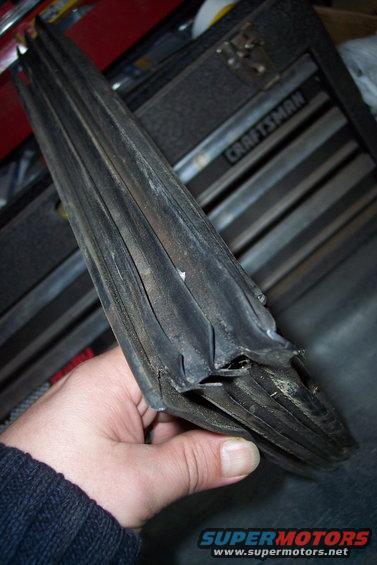 Hand holding a worn, folded rubber seal with multiple layers