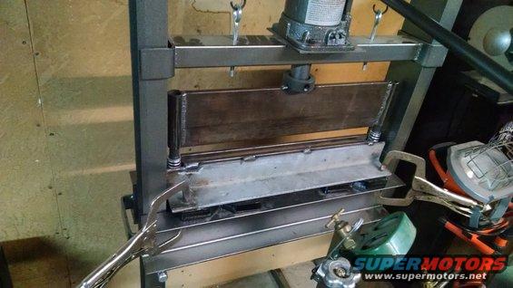 metal bending machine with clamps and a jack