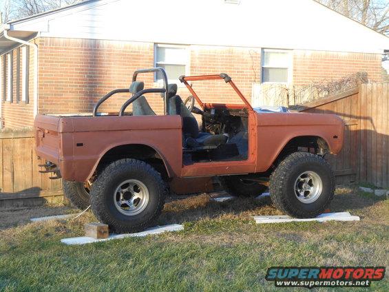 Orange 1972 Ford Bronco, doors removed, in a yard