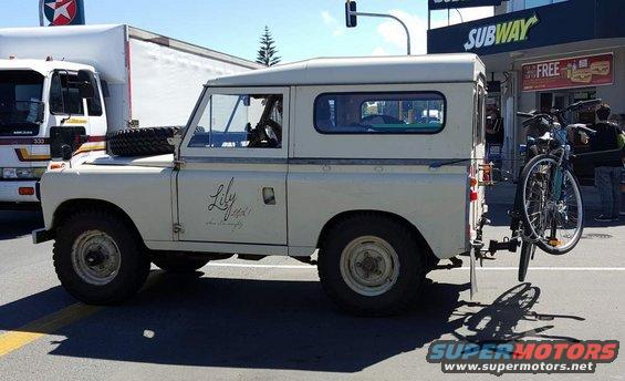 Cream Land Rover Defender with bicycle rack and bicycle on side