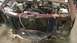2000 Chevrolet Astro - The front end of a maroon van is heavily damaged, revealing the engine compartment and radiator.