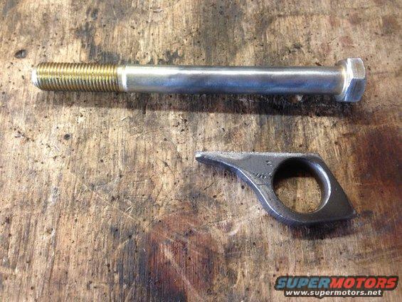 Bolt and custom metal bracket on wooden surface