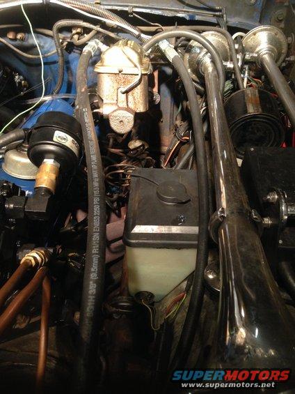 Engine bay showing brake master cylinder, hydroboost unit, and various hoses and wires