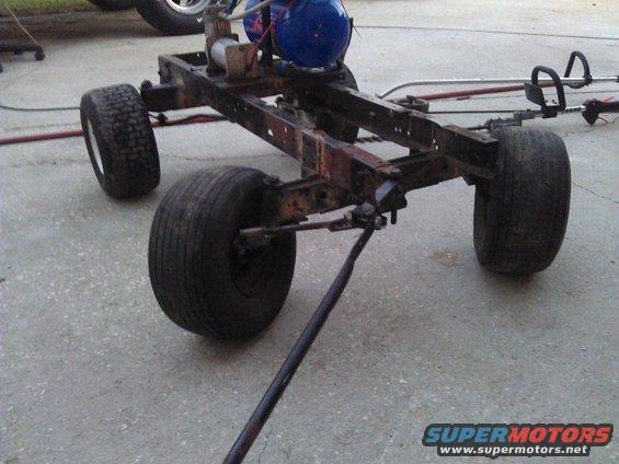 Rusted chassis with four wheels, blue tank, and air compressor