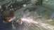 2000 Chevrolet Astro - A person works on a vehicle frame in a workshop, sparks flying from an angle grinder.