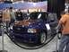 1995 Ford Bronco - A blue Ford Ranger pickup truck with an orange hood is displayed at an auto show.