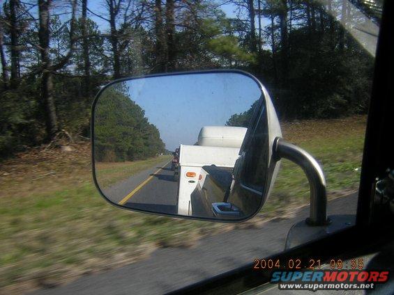 Trailer reflected in side mirror, towed by an unseen vehicle