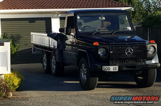 Black Mercedes G-Wagen with a flatbed in front of a garage