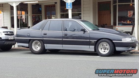 dark sedan with a raised hood parked next to a silver SUV