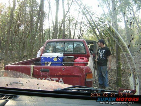 Red pickup truck bed with cooler and gas can. Toyota badging visible