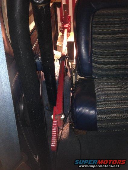 Interior view of a vehicle's storage compartment with a red jack and blue striped seat