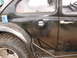 1964 Volkswagen Beetle - Side view of a black Volkswagen Beetle, modified with off-road tires and external roll cage elements.