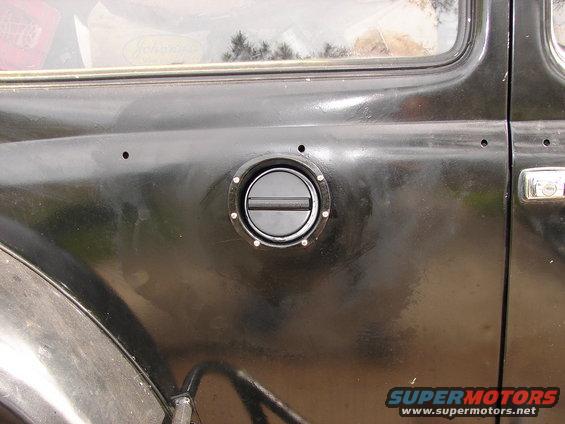 Black 1964 Volkswagen Beetle fuel filler door on the side of the vehicle