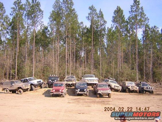 Brown 1984 Chevrolet Blazer parked on dirt with other off-road vehicles and trees