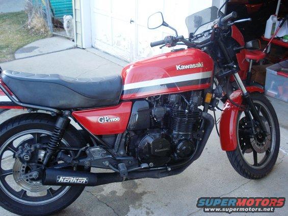 Red Kawasaki GP1100 motorcycle with black seat and Kerker exhaust, parked outdoors