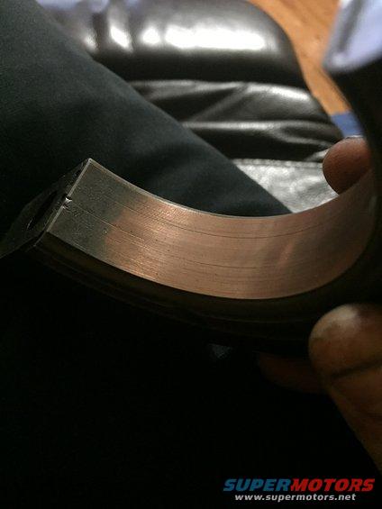Close-up of a worn engine bearing with copper showing through