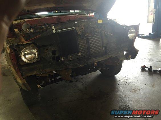 1978 Ford Bronco front end with hood open, missing grille and bumper, showing radiator