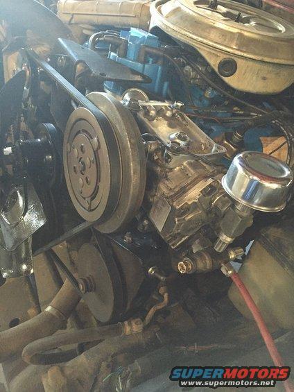 Engine bay showing the air conditioning compressor, belts, and pulleys
