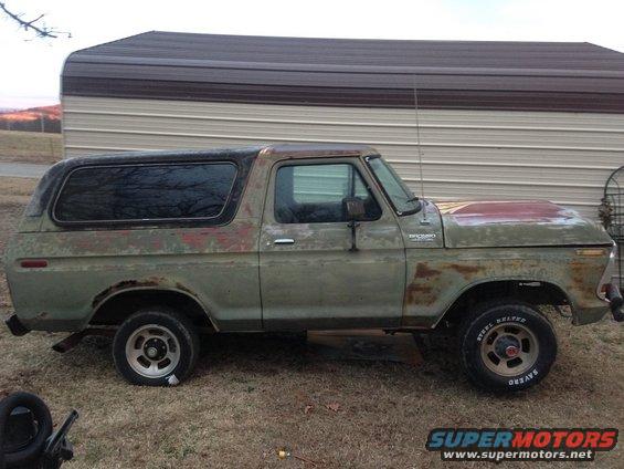 1978 Ford Bronco parked outside a metal building, showing rust and wear