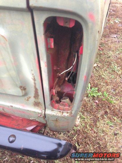 Rear taillight housing removed, showing wiring and interior of a vehicle